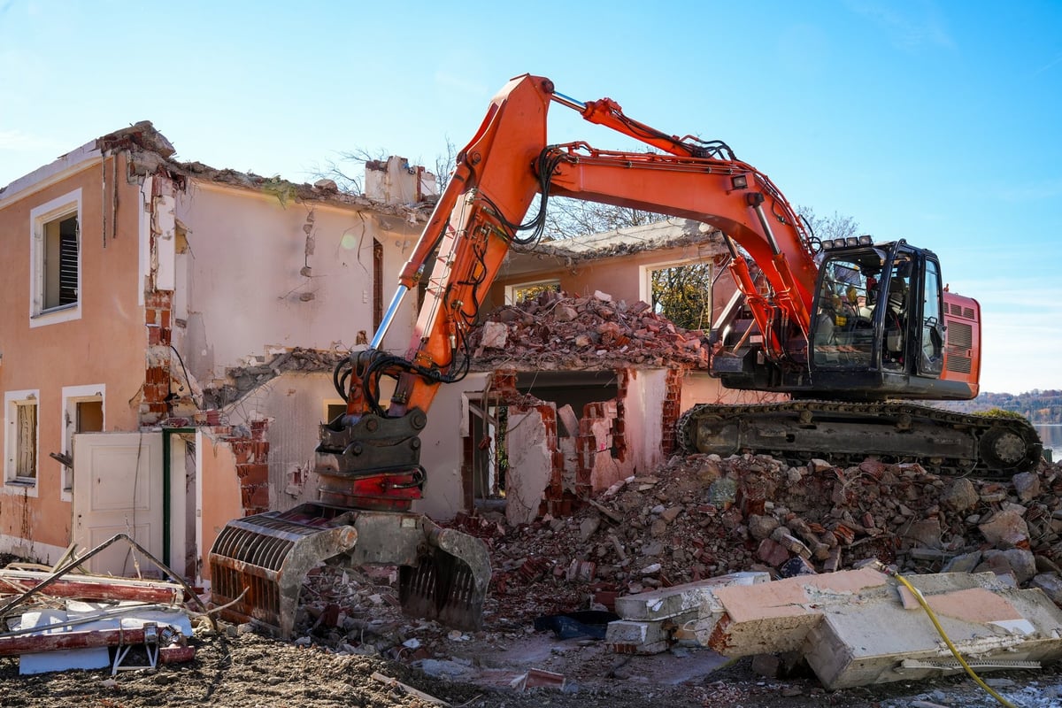 Excavator demolishing an old building on a construction site