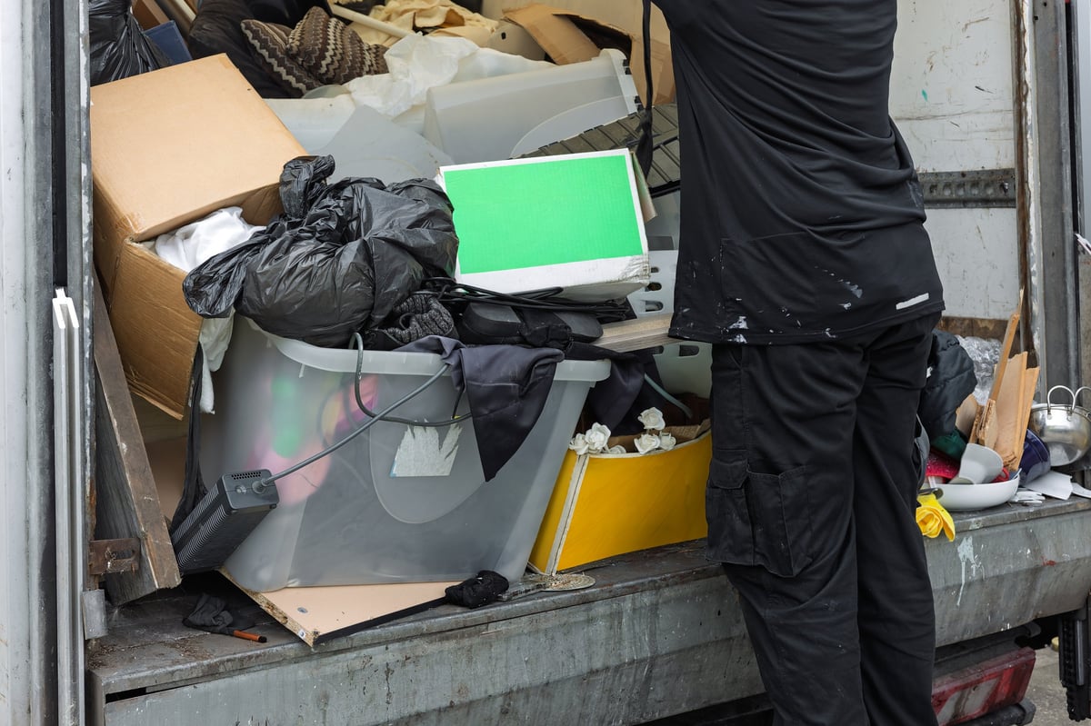 Worker unloading mixed waste from a commercial truck